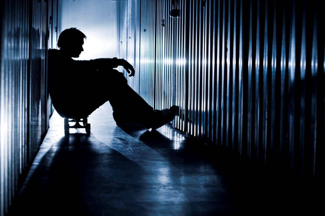 Silhouette of a person sitting on a small rolling stool in a long hallway. The image's tone suggests a feeling of isolation and is used to illustrate the importance of documentation in cases of false imprisonment.